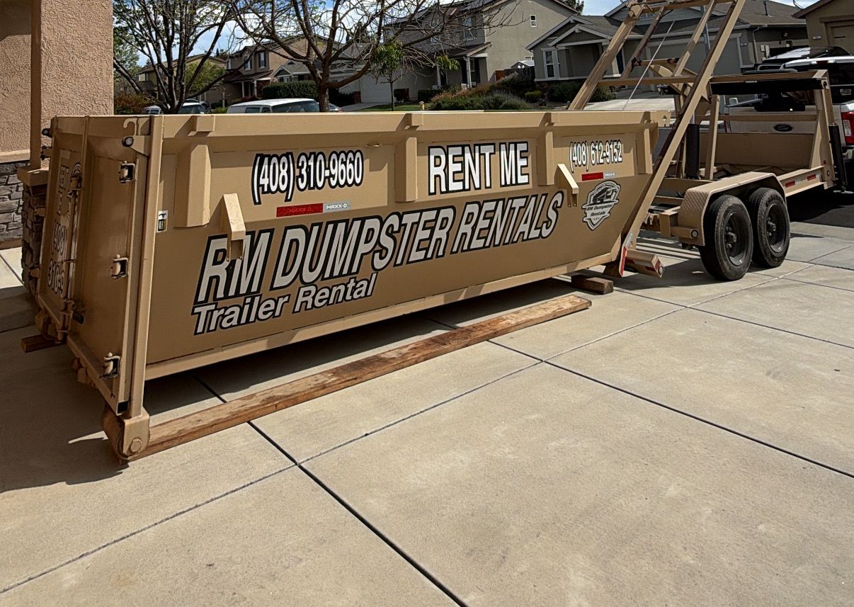 RM dumpster on boards in a driveway